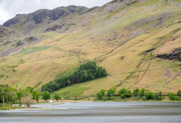 Vista del paisaje rural de campo verde y fondo de montaña bajo un cielo nublado en Inglaterra