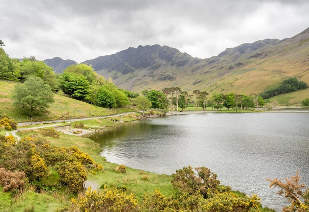 Vista del paisaje rural de campo verde y fondo de montaña bajo un cielo nublado en Inglaterra