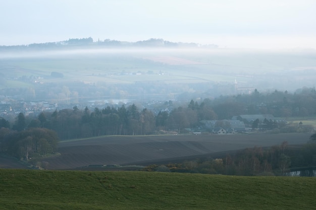 Vista de un paisaje rural escocés con ciudad y campos en una mañana de niebla en Linlithgow, Escocia