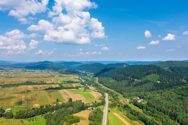 Vista panorâmica aérea da estrada rural e dos campos cultivados nas colinas