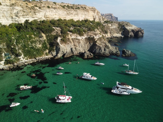 Vista panorâmica aérea da paisagem marinha com mar azul cristalino e costas rochosas Iates em uma bela lagoa no pano de fundo das rochas O conceito de um destino ideal para viagens de verão e férias