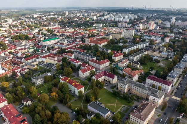 Vista panorâmica aérea de uma grande altura de uma pequena cidade verde provincial com setor privado e prédios de apartamentos altos