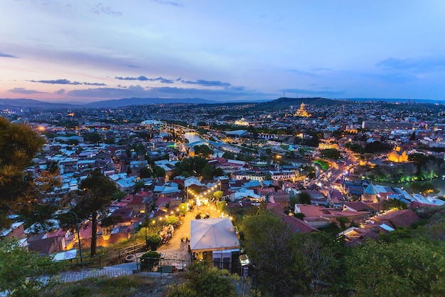 Foto vista panorámica del atardecer de tbilisi capital de georgia país iglesia de metekhi catedral de la santa trinidad