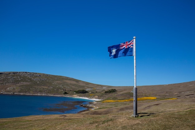 Vista panorámica de la bandera en la montaña contra un cielo azul claro