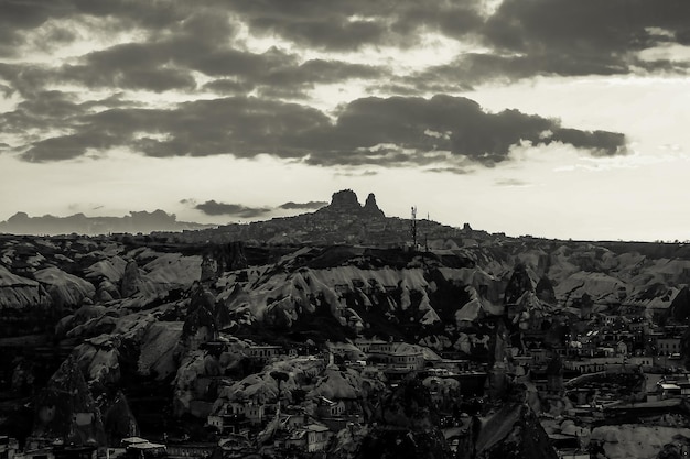 Vista panorámica en blanco y negro de la ciudad de Goreme durante la puesta de sol