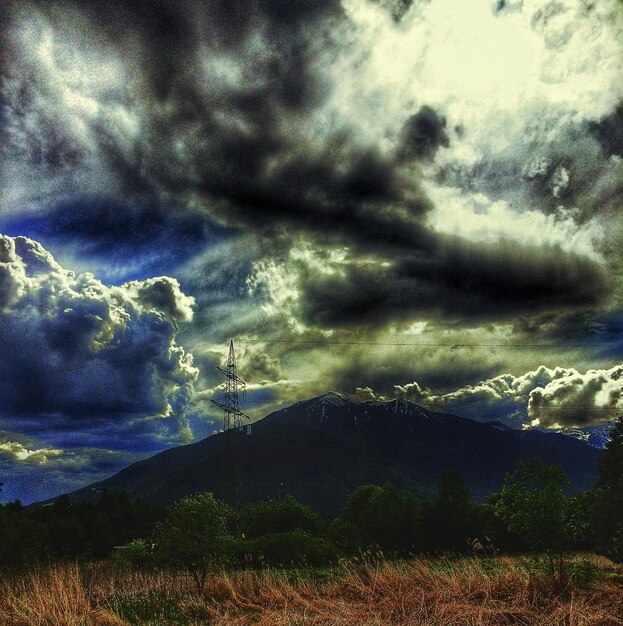 Vista panorámica de un campo de hierba junto a la montaña contra un cielo nublado