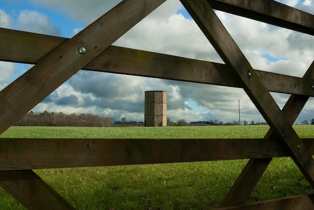 Foto vista panorámica de un campo de hierba visto a través de una valla de madera