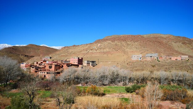 Vista panorámica de casas y montañas contra un cielo azul claro