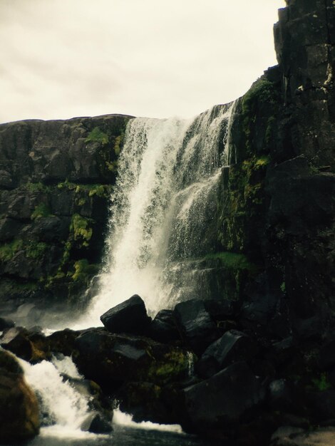 Foto vista panorámica de una cascada que fluye sobre las rocas