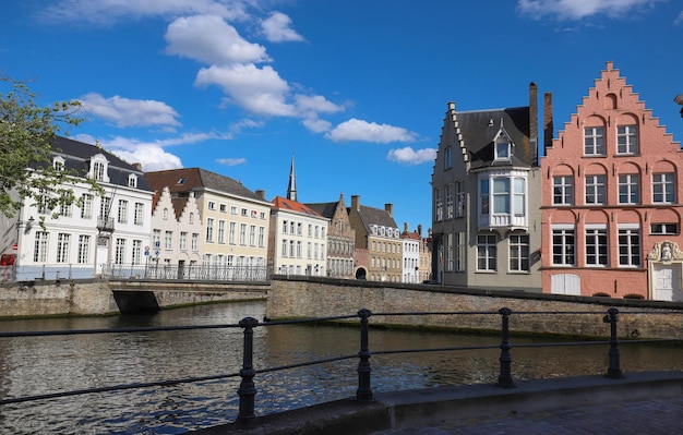 Vista panorámica de la ciudad del canal de Brujas con hermosos puentes de casas medievales de colores y reflejos en el día soleado