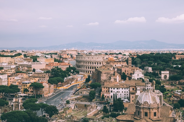 Foto vista panorámica de la ciudad de roma con el foro romano y el coliseo del monumento a vittorio emanuele ii, también conocido como el vittoriano. día soleado de verano y espectacular cielo azul