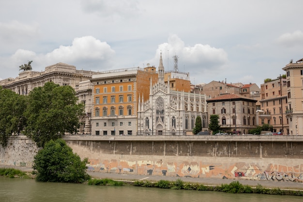 Vista panorámica de la ciudad de Roma con el río Tíber y la antigua iglesia en la otra costa. Día de verano y espectacular cielo azul.