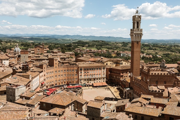 Vista panorámica de la ciudad de Siena con la Piazza del Campo y la Torre del Mangia es una torre en la ciudad de la Catedral de Siena (Duomo di Siena). Día soleado de verano y espectacular cielo azul