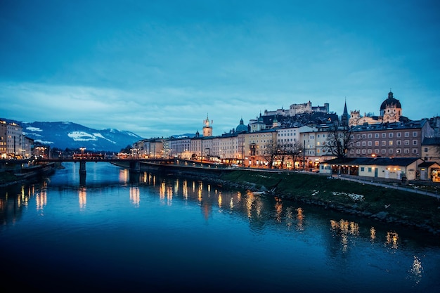 Vista panorâmica com a paisagem da cidade velha e o castelo de Hohensalzburg em Salzburgo, na Áustria, na Europa. Cidade de Mozart nos Alpes austríacos e Rio Salzach no inverno. Fortaleza e Catedral. Ao entardecer