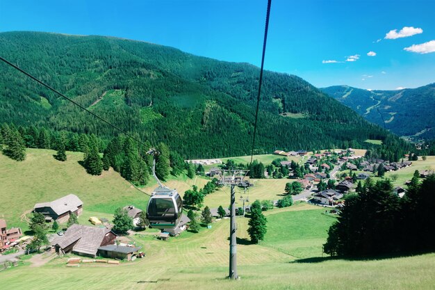 Vista panorâmica com teleféricos nas montanhas e céu azul em Bad Kleinkirchheim, Caríntia da Áustria. Colinas austríacas e vales verdes. Natureza paisagem ao ar livre. Viagens e turismo no verão.