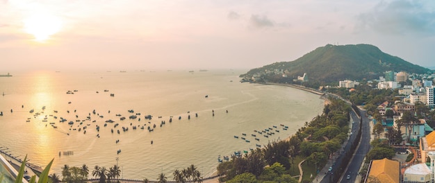 Vista panorámica costera de Vung Tau desde arriba con olas, calles costeras, cocoteros, montaña