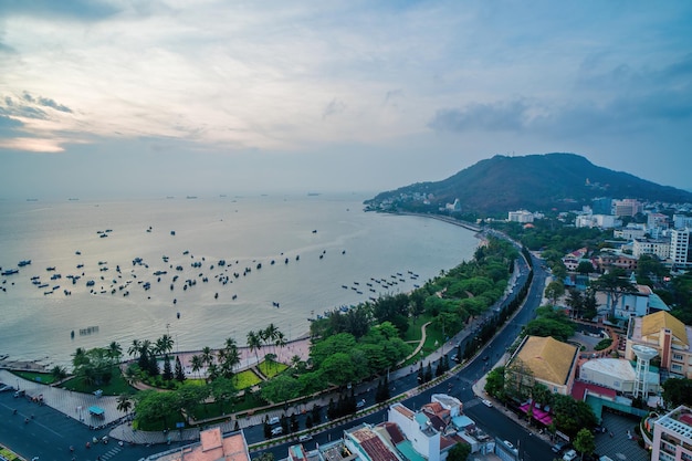 Vista panorámica costera de Vung Tau desde arriba con olas, calles costeras, cocoteros, montaña