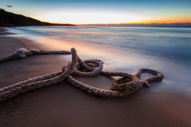 Vista panorámica de la cuerda del barco en la playa contra el cielo durante el amanecer