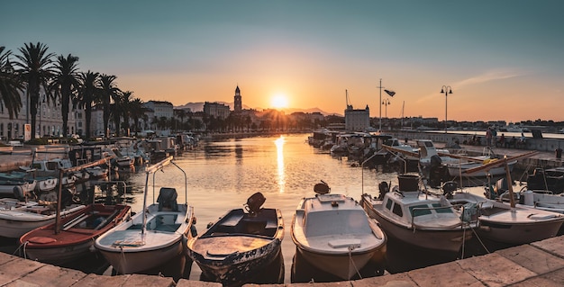 Vista panorâmica da bela cidade de Split ao nascer do sol com aterro, palmeiras, iates e barcos à vela no mar. Croácia, Europa, conceito de viagens.