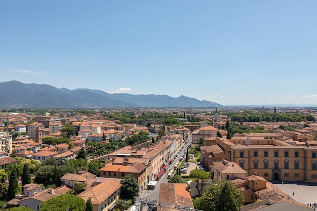 Vista panorâmica da cidade de pisa com edifícios históricos e montanhas distantes da torre de pisa. dia de verão e céu azul ensolarado