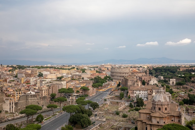 Vista panorâmica da cidade de Roma com o Fórum Romano e o Coliseu do Monumento Vittorio Emanuele II, também conhecido como Vittoriano. Dia ensolarado de verão e céu azul dramático