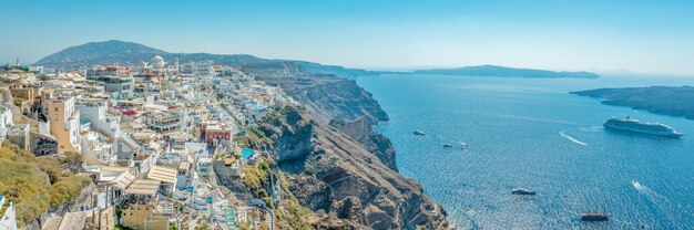 Vista panorâmica da cidade de thira com casas tradicionais e famosas e igrejas com cúpulas azuis