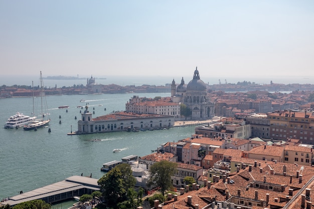 Vista panorâmica da cidade de Veneza e da Basílica di Santa Maria della Salute (Santa Maria de Healt) do Campanile de São Marcos (Campanile di San Marco). Paisagem de dia de verão e céu azul ensolarado