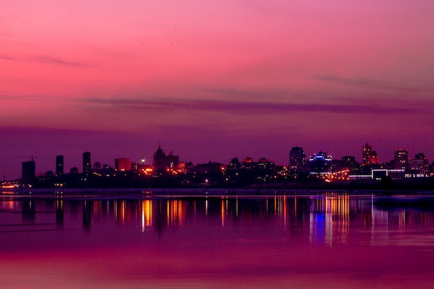 Vista panorâmica da cidade no centro durante o pôr do sol rosa e roxo.