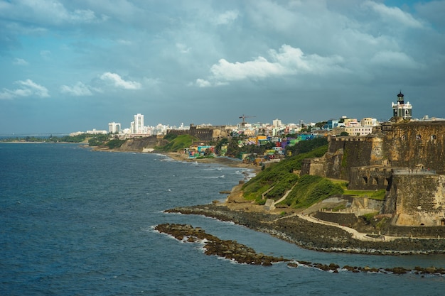 Vista panorâmica da colorida cidade histórica de Porto Rico à distância com o forte em primeiro plano