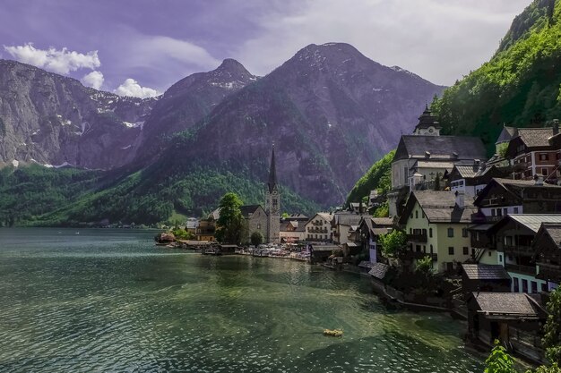 Vista panorâmica da famosa vila na montanha Hallstatt e da Igreja Evangélica com o lago Hallstatter