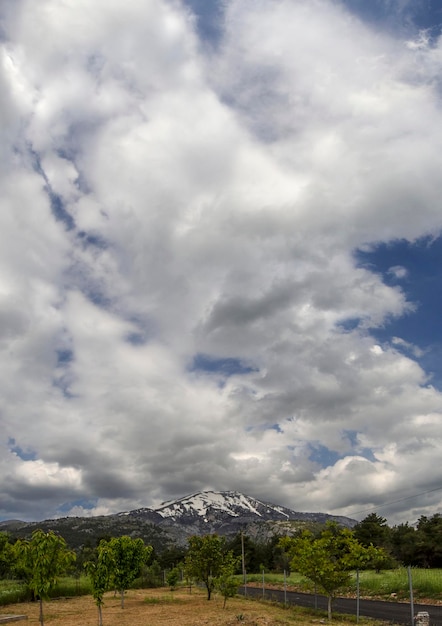 Vista panorâmica da montanha coberta de neve Dirfys igreja e céu com nuvens na ilha de Evia