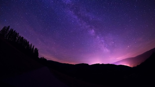 Vista panorâmica da montanha em silhueta contra o campo de estrelas