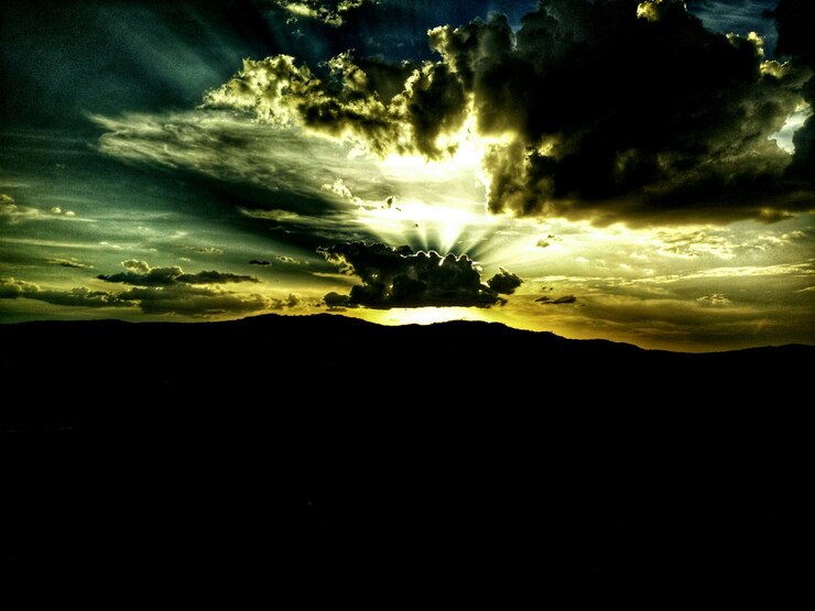 Foto vista panorâmica da paisagem de silhueta contra o céu nublado durante o pôr-do-sol