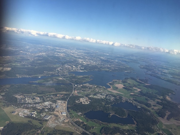 Vista panorâmica da paisagem e do mar contra o rio contra o céu visto da janela do avião