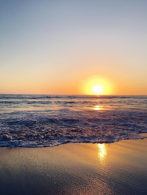 Vista panorâmica da praia contra o céu ao pôr-do-sol