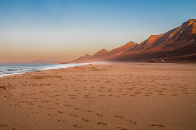 Vista panorâmica da praia contra o céu durante o pôr-do-sol