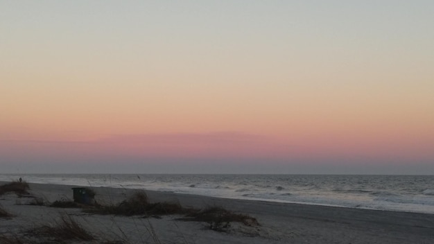 Foto vista panorâmica da praia contra o céu limpo durante o pôr do sol