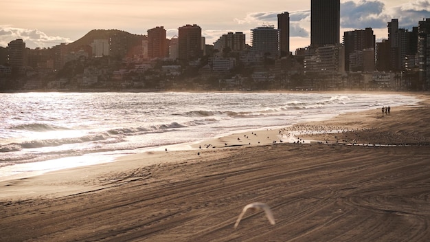 Foto vista panorâmica da praia e dos edifícios contra o céu durante o pôr-do-sol