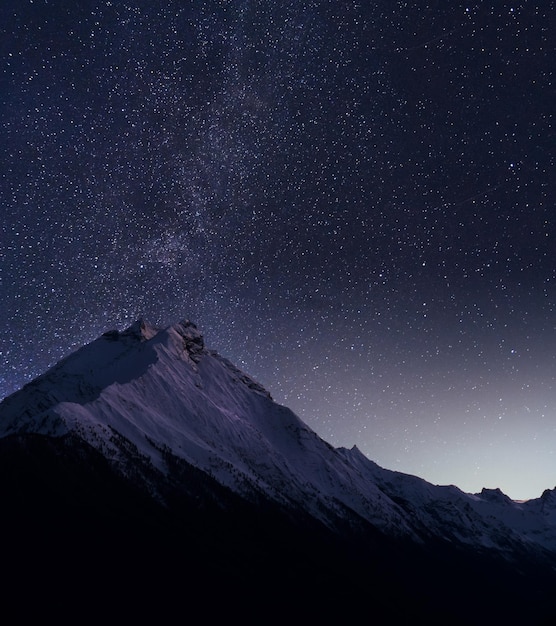 Vista panorâmica das montanhas contra o campo de estrelas à noite