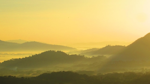 Vista panorâmica das montanhas durante o tempo nebuloso de manhã