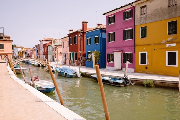 Vista panorâmica de casas coloridas e canal de água com barcos em Burano, é uma ilha na Lagoa de Veneza. Dia ensolarado de verão e céu azul