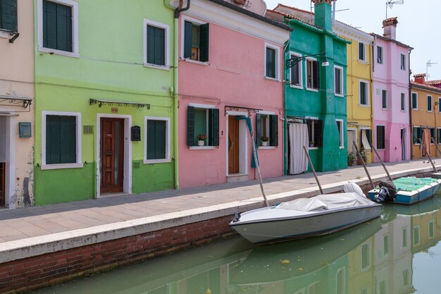 Vista panorâmica de casas coloridas e canal de água com barcos em Burano, é uma ilha na Lagoa de Veneza. Dia ensolarado de verão e céu azul