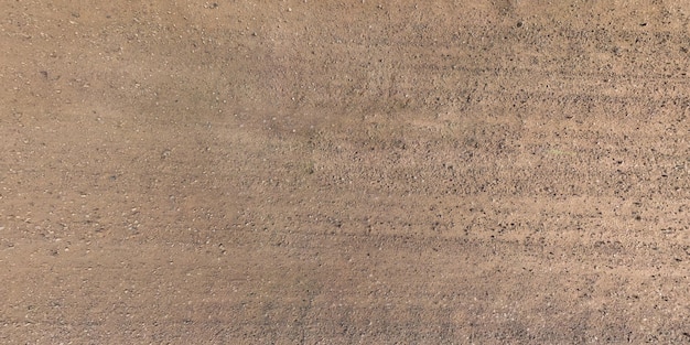 Vista panorâmica de cima na textura da estrada de cascalho com marcas de pneus de carro