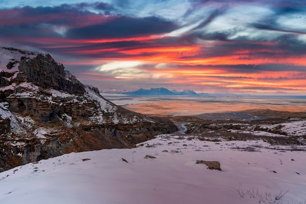 Vista panorâmica de falésias rochosas na paisagem coberta de neve contra o céu durante o pôr do sol