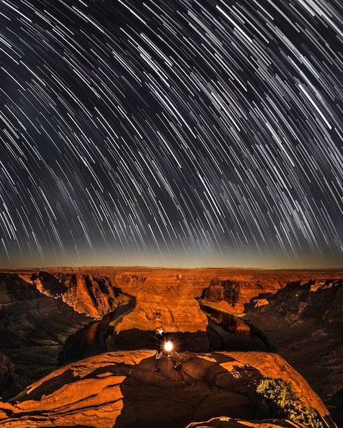 Vista panorâmica de formação rochosa iluminada contra o céu à noite