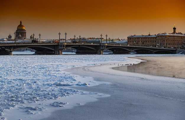 Vista panorâmica de inverno de são petersburgo ao pôr do sol na catedral isaac e ponte blagoveshenskiy no fundo...