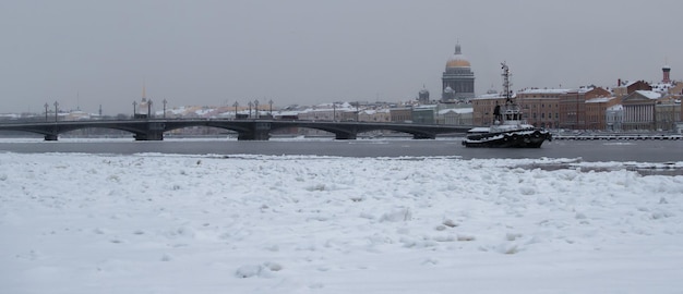 Vista panorâmica de inverno de são petersburgo no dia gelado, a catedral de isaac e a ponte blagoveshenskiy no fundo, vapor sobre o rio neva congelado, edifício do almirantado