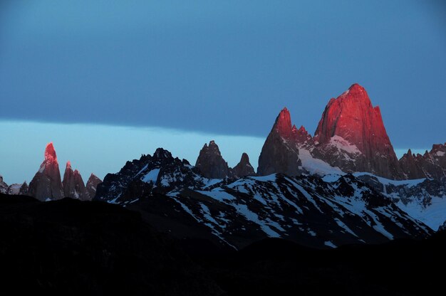 Vista panorâmica de montanhas cobertas de neve contra o céu azul ao amanhecer