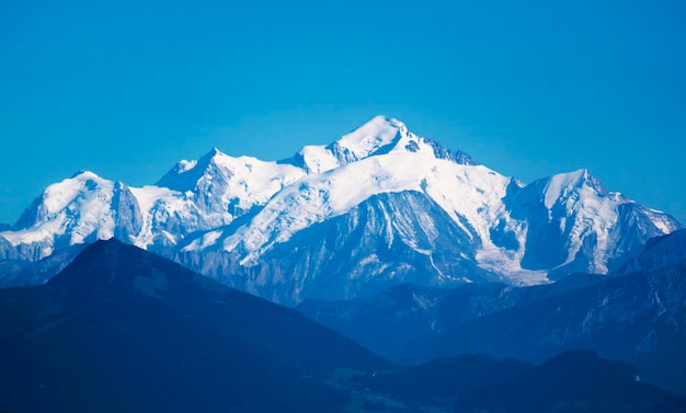 Foto vista panorâmica de montanhas cobertas de neve contra um céu azul claro