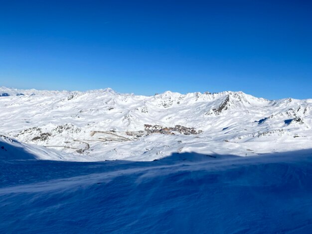 Foto vista panorâmica de montanhas cobertas de neve contra um céu azul claro